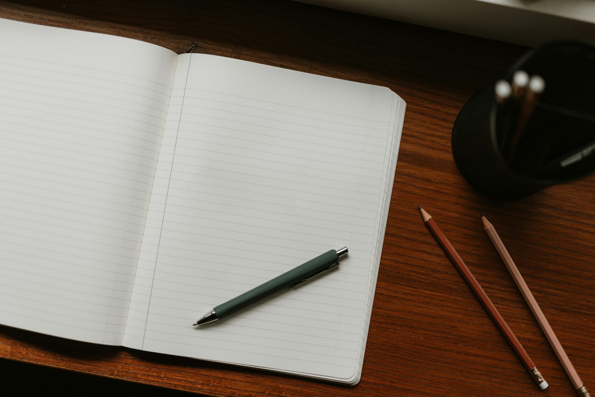 Open notebook with a hand writing during a planning conversation.