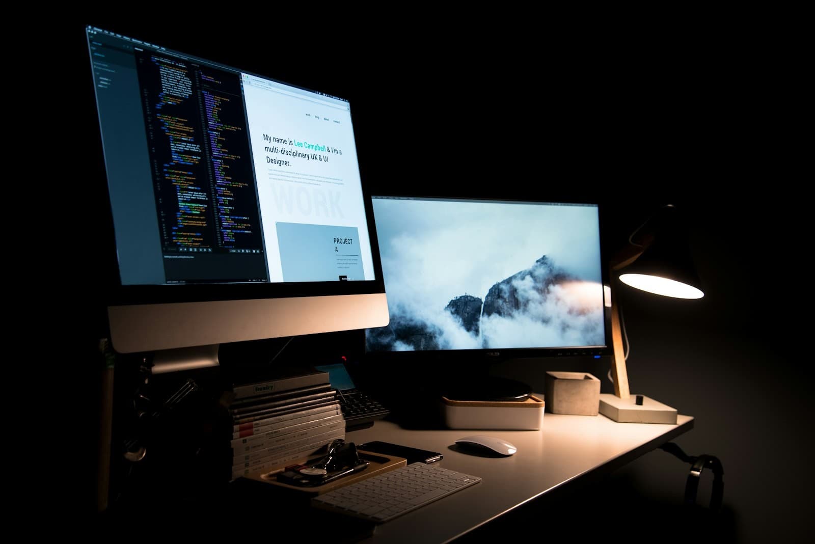 Dark workspace with a clean, modern website design on a desktop monitor.